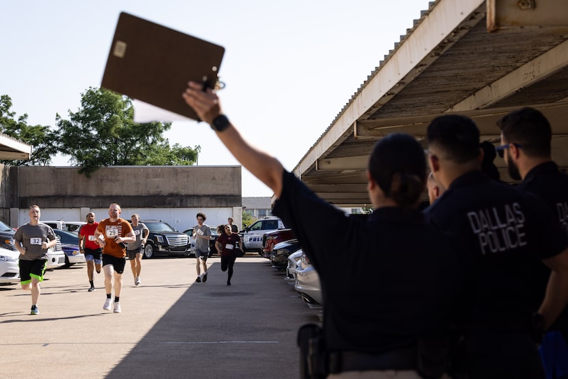Dallas Police Officer Alyssa Flores calls out times for applicants running a 300 meter run...