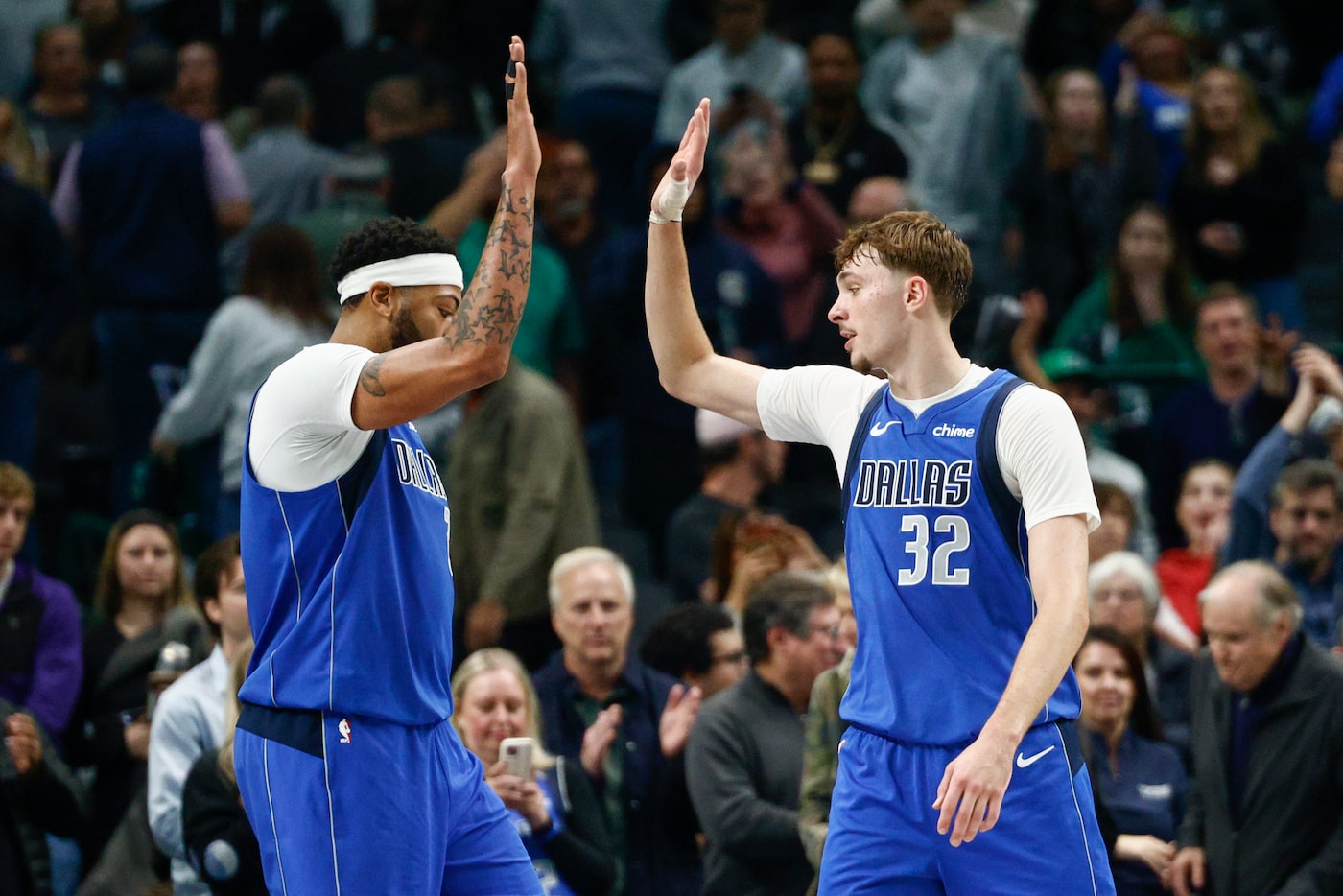 Dallas Mavericks forward Cooper Flagg (32) high-fives forward Anthony Davis (3) after...