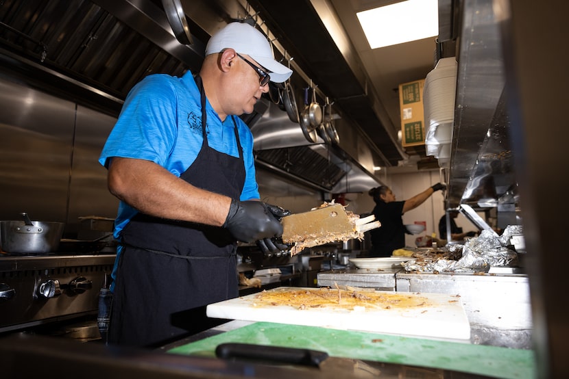 Ricardo Luis chops birria, or slow-cooked goat meat, during lunchtime at Birrieria Los...