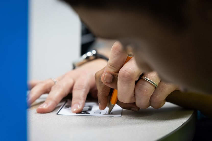 A paraprofessional assists a Structured Academics and Interpersonal Learning or SAIL fill in...