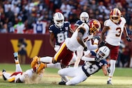 Dallas Cowboys running back Malik Davis (43) is brought down by Washington Commanders safety...