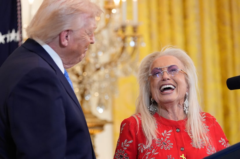 President Donald Trump listens as Miriam Adelson speaks during a Hanukkah reception in the...
