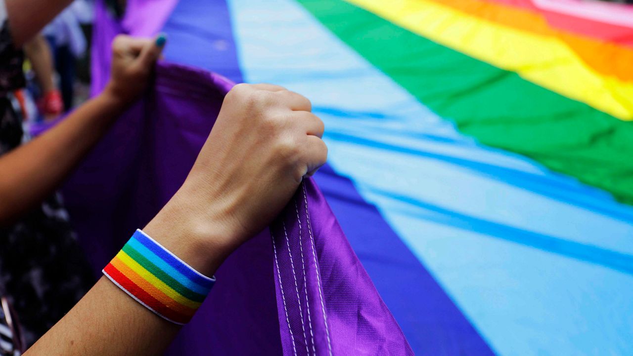 In this Sunday, June 3, 2018 file photo, revelers at the annual gay pride parade hold up a giant rainbow flag in Sao Paulo, Brazil. (AP Photo/Nelson Antoine, File)