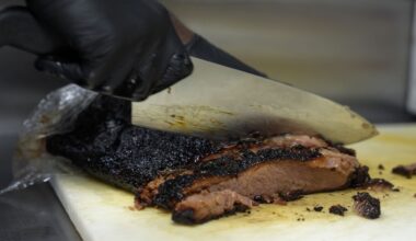 A line cook slices beef brisket, Wednesday, June 12, 2024, at a barbecue restaurant in Cincinnati. (AP Photo/Joshua A. Bickel)