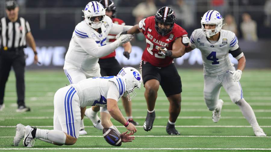 ARLINGTON, TEXAS - DECEMBER 06: Bear Bachmeier #47 of the BYU Cougars recovers a bad snap against t...