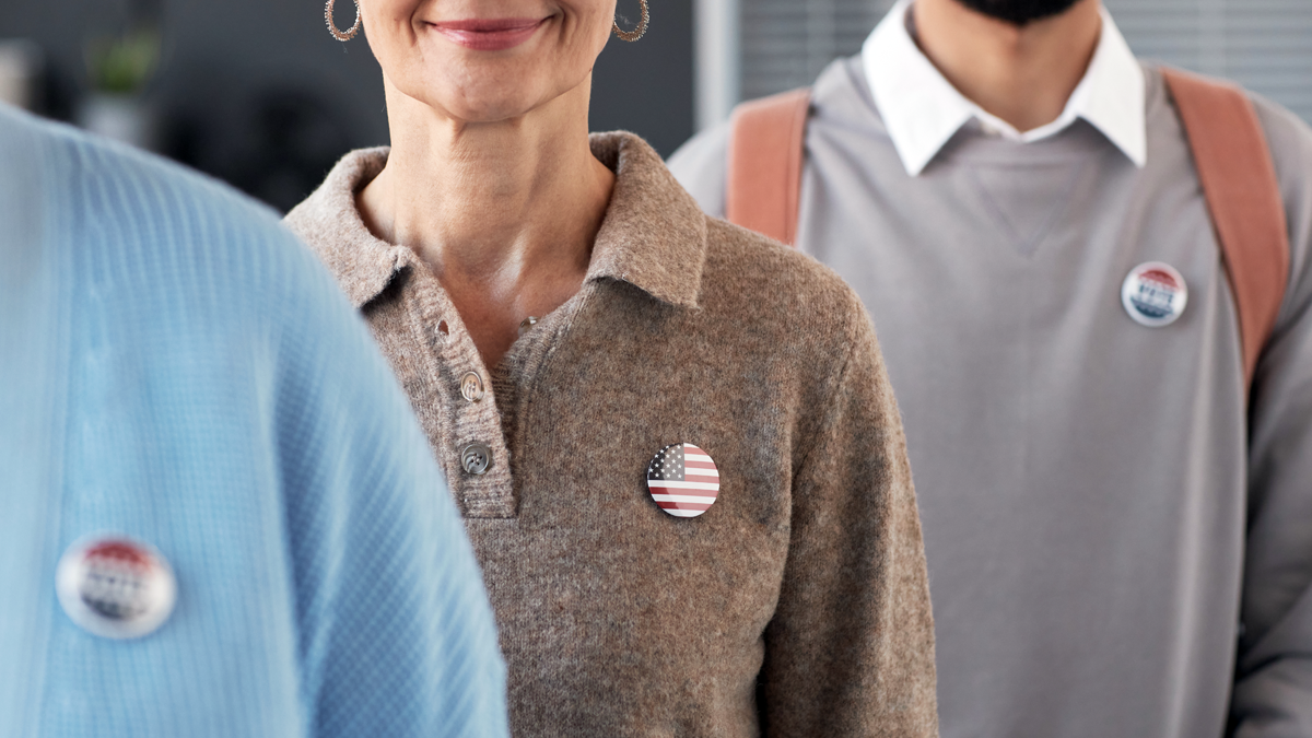 A picture of people wearing election buttons waiting in line to file documents.