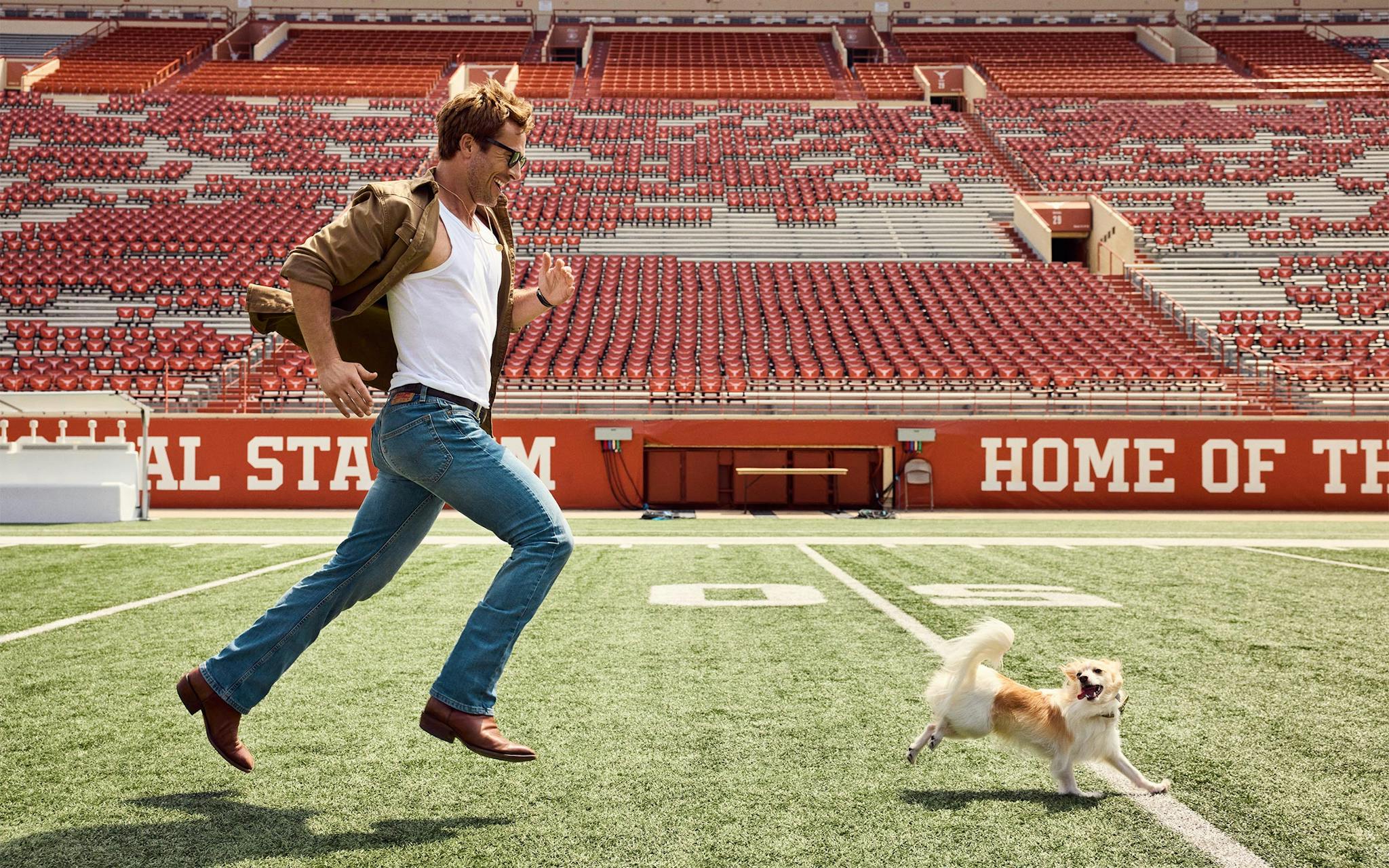 photo of glen running after dog on football field