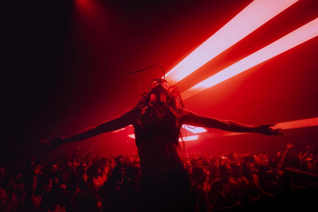 A silhouette of a person in a nightclub, backlit by red light.