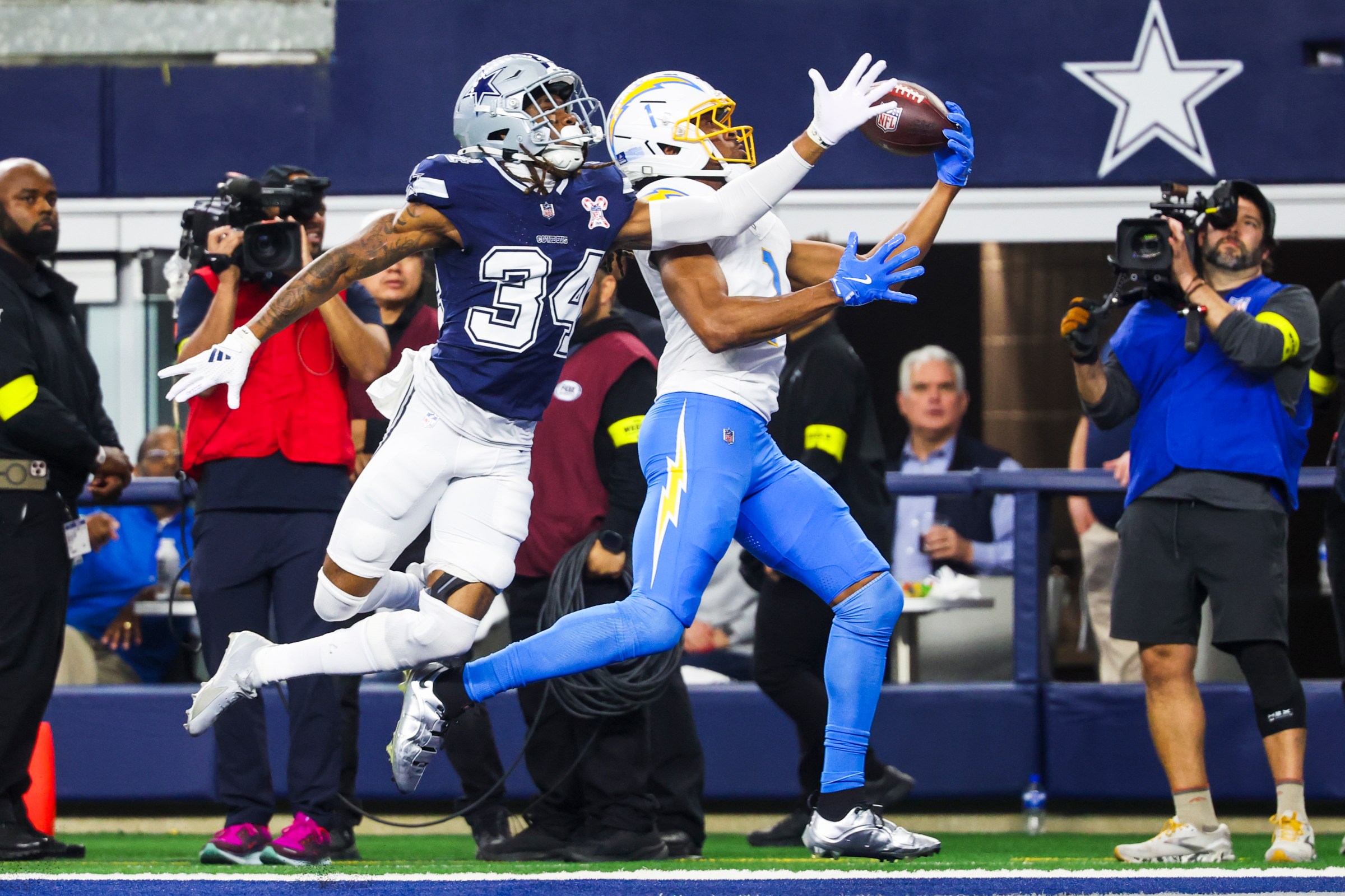 Dec 21, 2025; Arlington, Texas, USA; Los Angeles Chargers wide receiver Quentin Johnston (1) catches a touchdown pass against Dallas Cowboys cornerback Shavon Revel Jr. (34) during the first quarter at AT&T Stadium. Mandatory Credit: Kevin Jairaj-Imagn Images