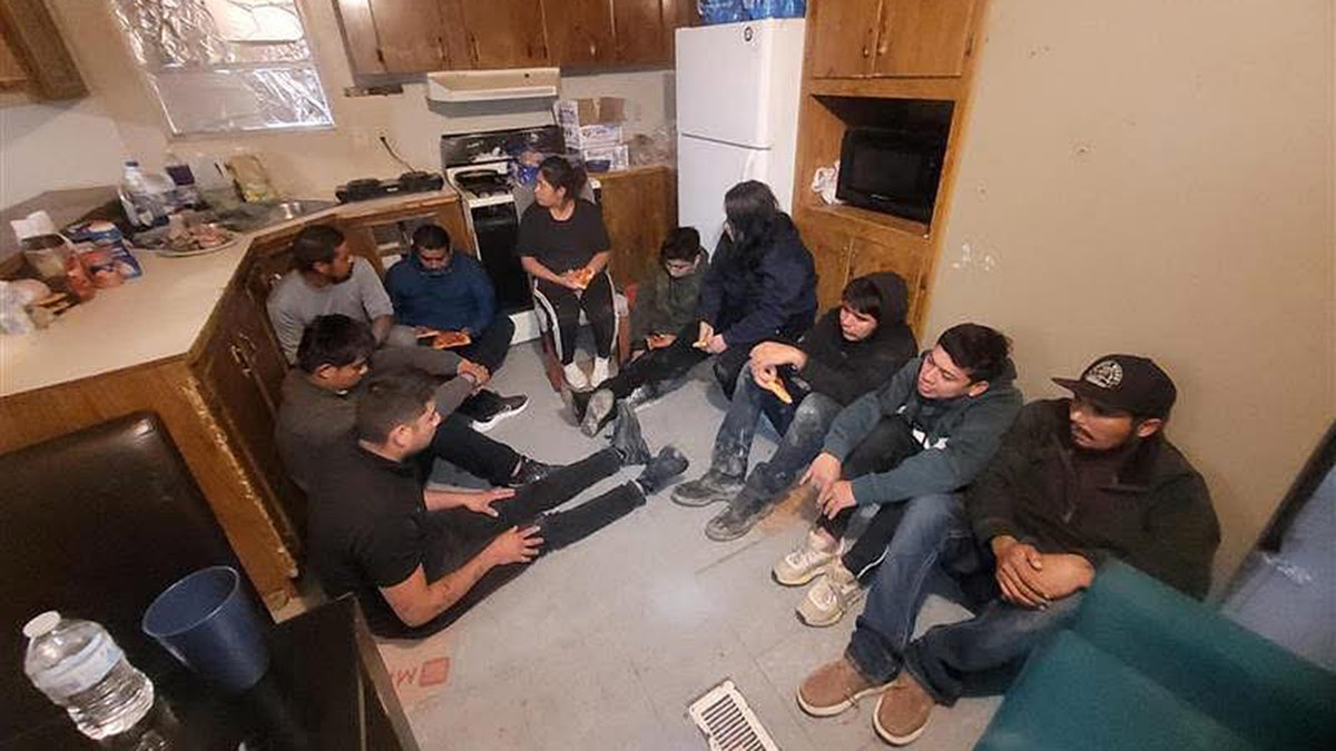 Alleged illegal immigrants sit inside of a home in Laredo, Texas