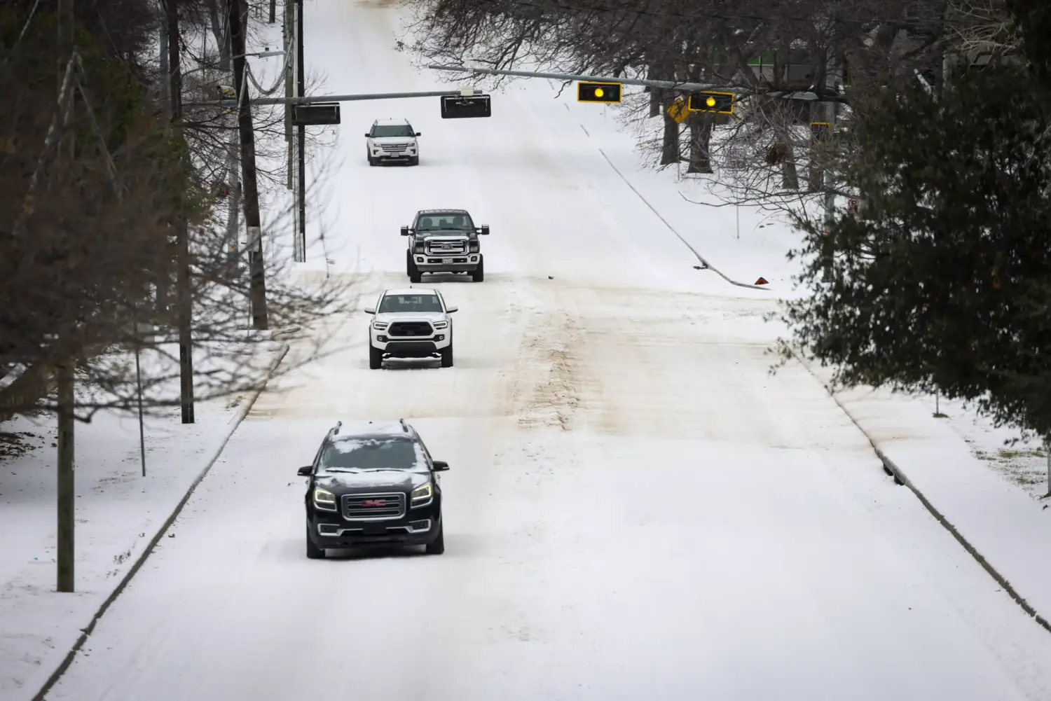Cars navigate icy roads after Winter Storm Fern passes the area Sunday, Jan. 25, 2026, in Dallas.