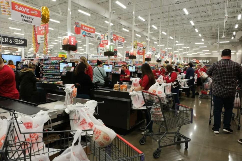 H-E-B employees scan shoppers' groceries as they check out during the store's first day of operations April 10, 2024.