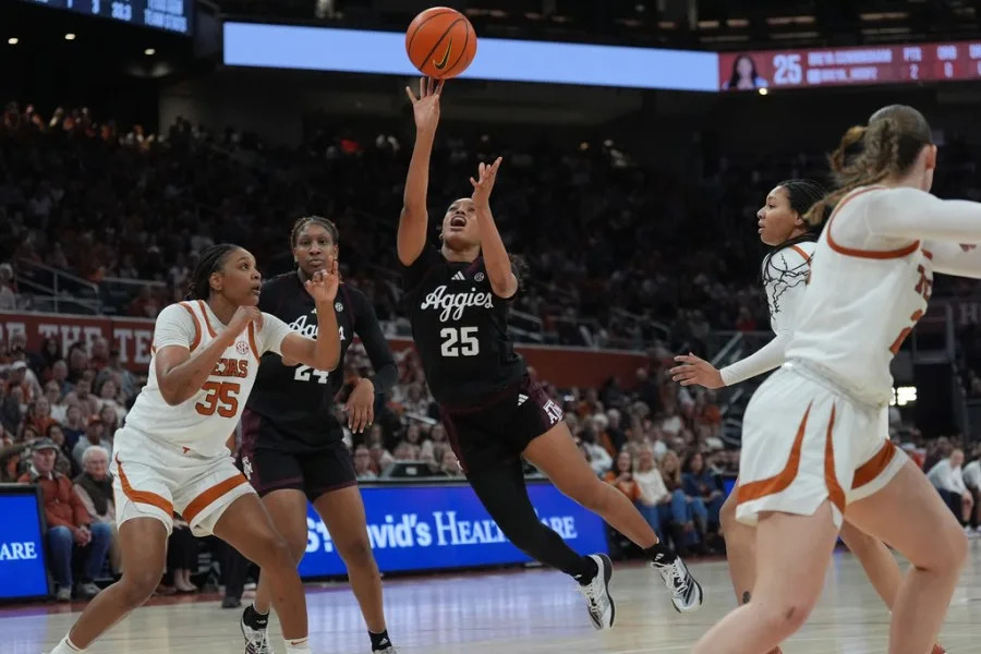 Texas A&M guard Salese Blow (25) shoots past Texas forward Madison Booker (35) during the first half of an NCAA college basketball game in Austin, Texas, Sunday, Jan. 18, 2026. (AP Photo/Eric Gay)
