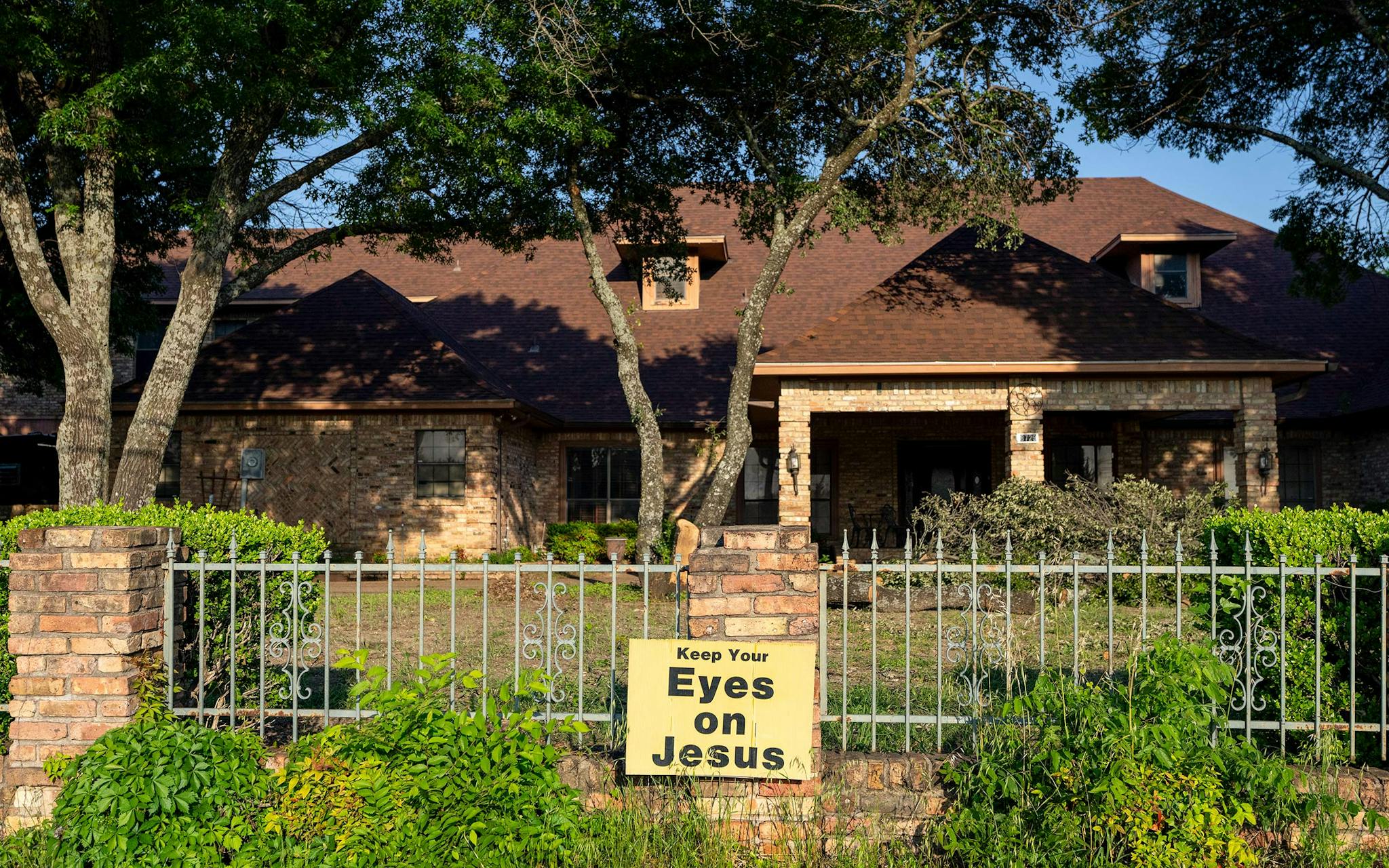 May 10 8:00 A.M. A sign that reads “Keep Your Eyes on Jesus” adorns the fence outside a home in far South Dallas.