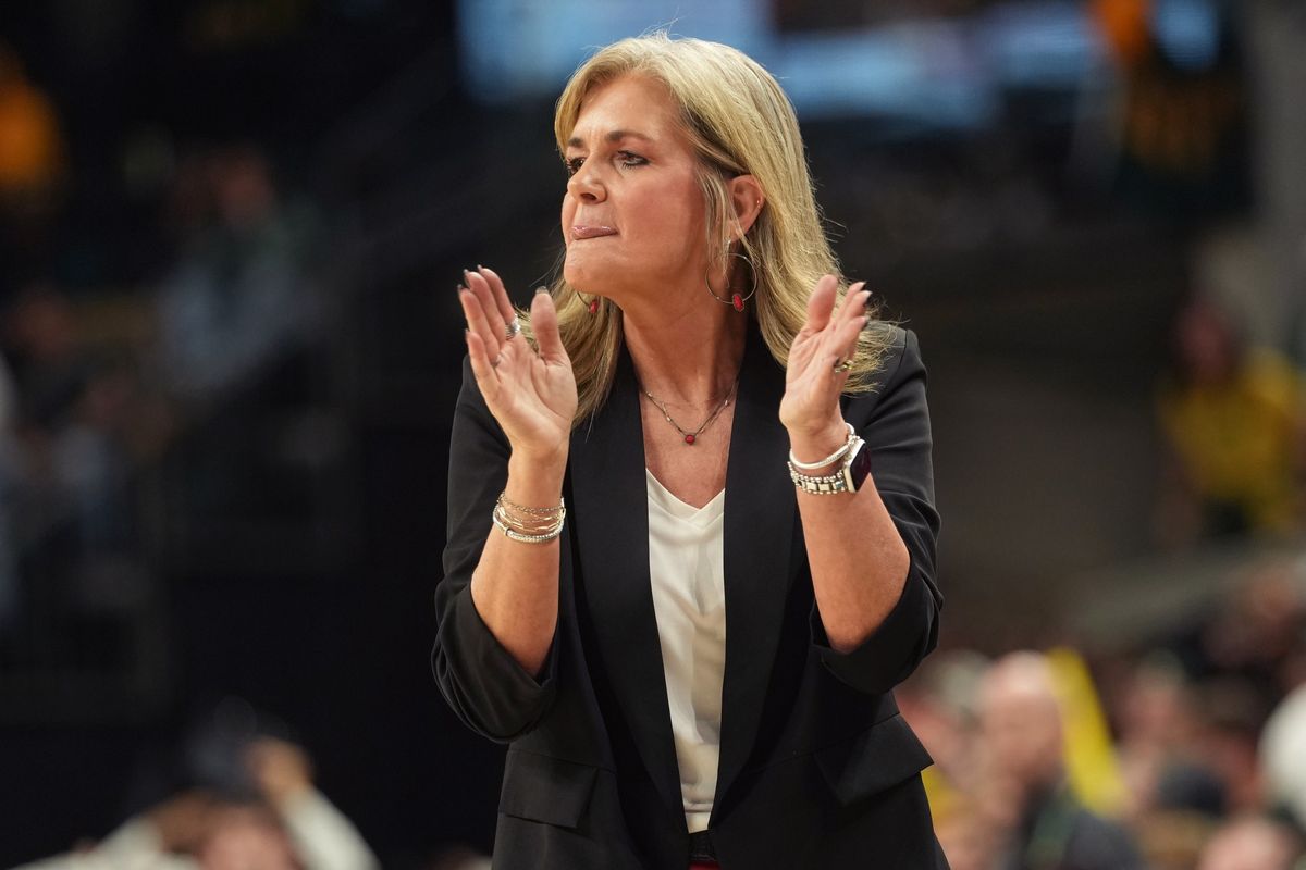 Krista Gerlich claps while standing beside the court