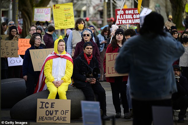 Anti-ICE activists display signs during a protest in Portland, Oregon