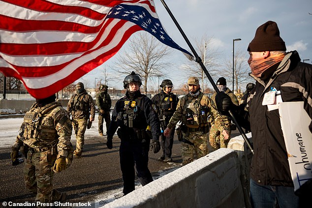 Federal agents escort gather before a rally for Renee Good, who was fatally shot by an ICE officer earlier in the week, at a federal building in Minneapolis on Saturday