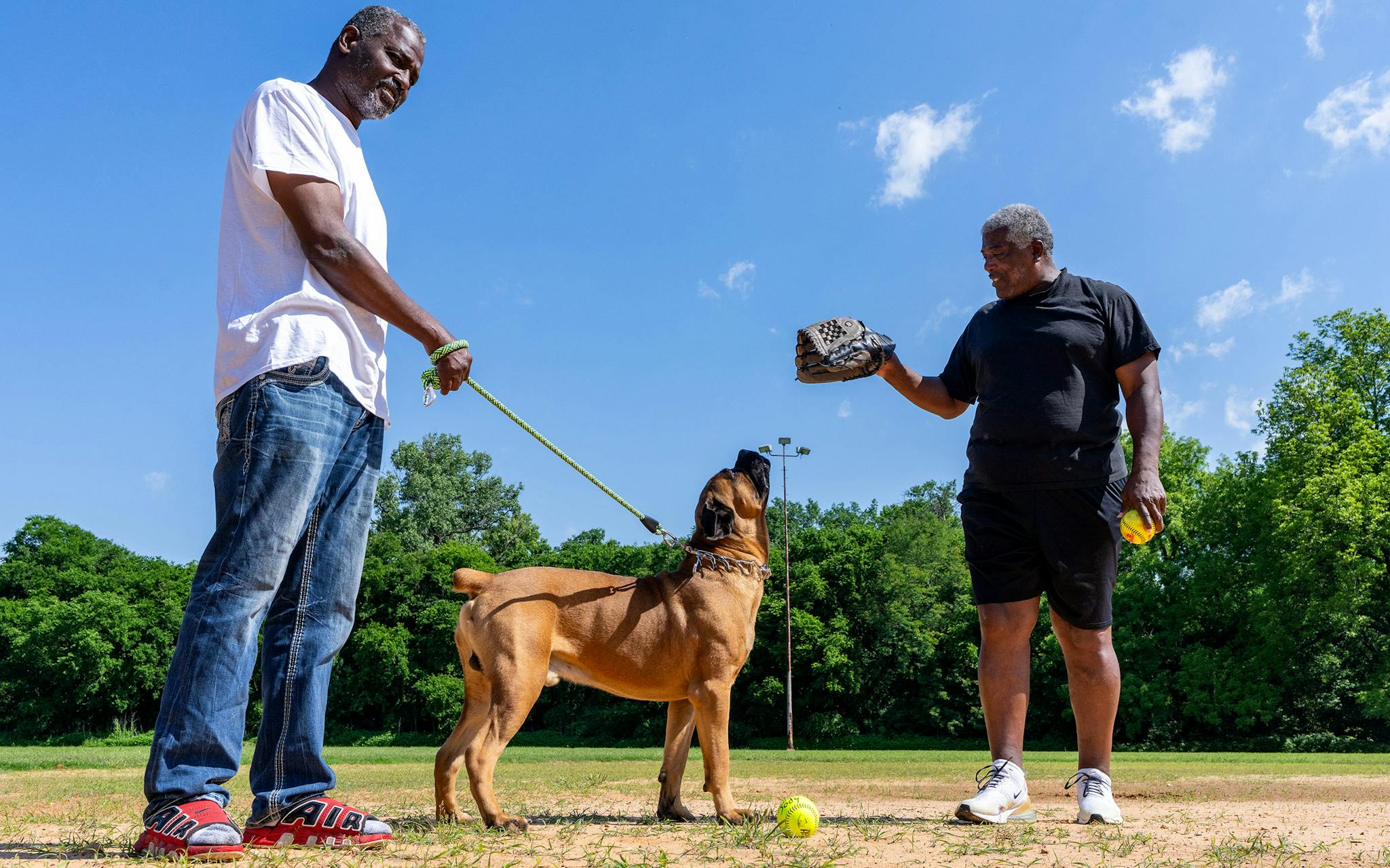 May 10 10:32 A.M. Dwain Banks, 65, (right) greets Zeus, a 2-year-old, 170-pound Cane Corso, that belongs to Robert Daniels, 55, (left) at College Park in South Dallas. Banks, who attends Community Missionary Baptist Church in DeSoto, was at the park for a softball practice he had organized for adult members of various area churches. Daniels was a friend of Banks’ who had stopped by with his dog to say hello.