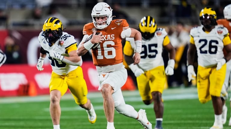 Texas quarterback Arch Manning (16) outruns the Michigan defense on...