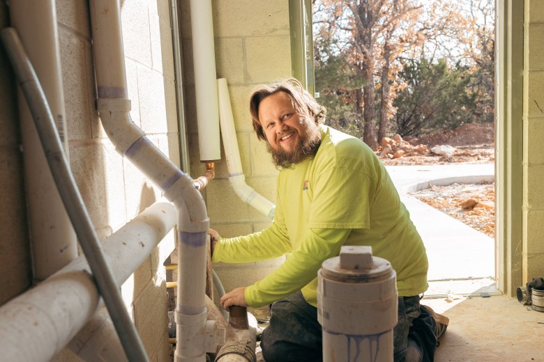 Justin Davis works on the plumbing at a restroom near the campgrounds at Palo Pinto Mountains State Park on Dec. 15, 2025.