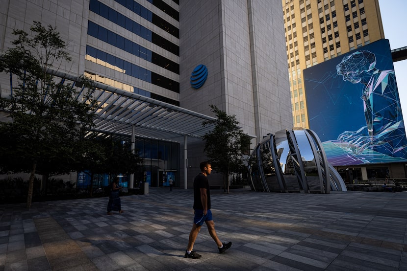 Pedestrians walk through AT&T Discovery District past the communications company’s...