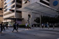 Pedestrians cross to and from AT&T Discovery District on Commerce Street past the...