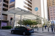 A car drives past AT&T headquarters building Whitacre Tower and the AT&T Discovery District...