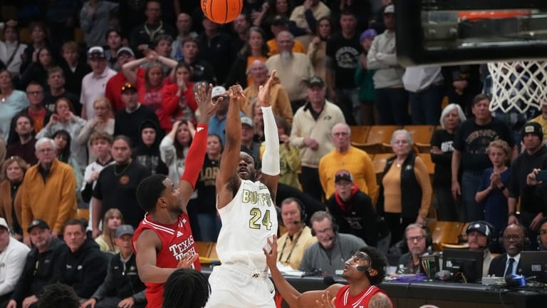 Colorado guard Barrington Hargress, center, shoots a last-second, 3-point basket...