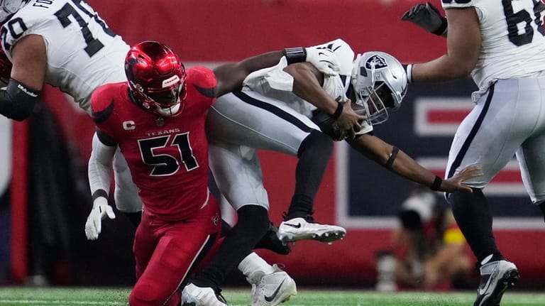 Las Vegas Raiders quarterback Geno Smith, right, scrambles away from...