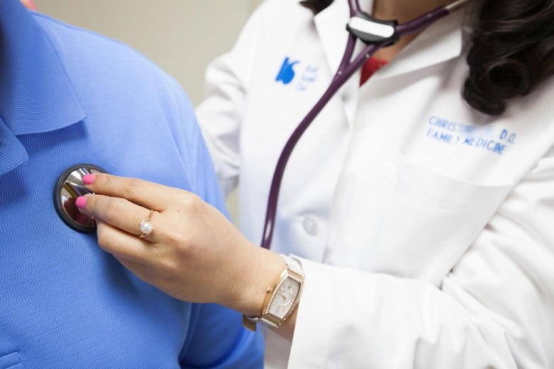 A physician at a Houston clinic checks up on her patient on June 10, 2014.
