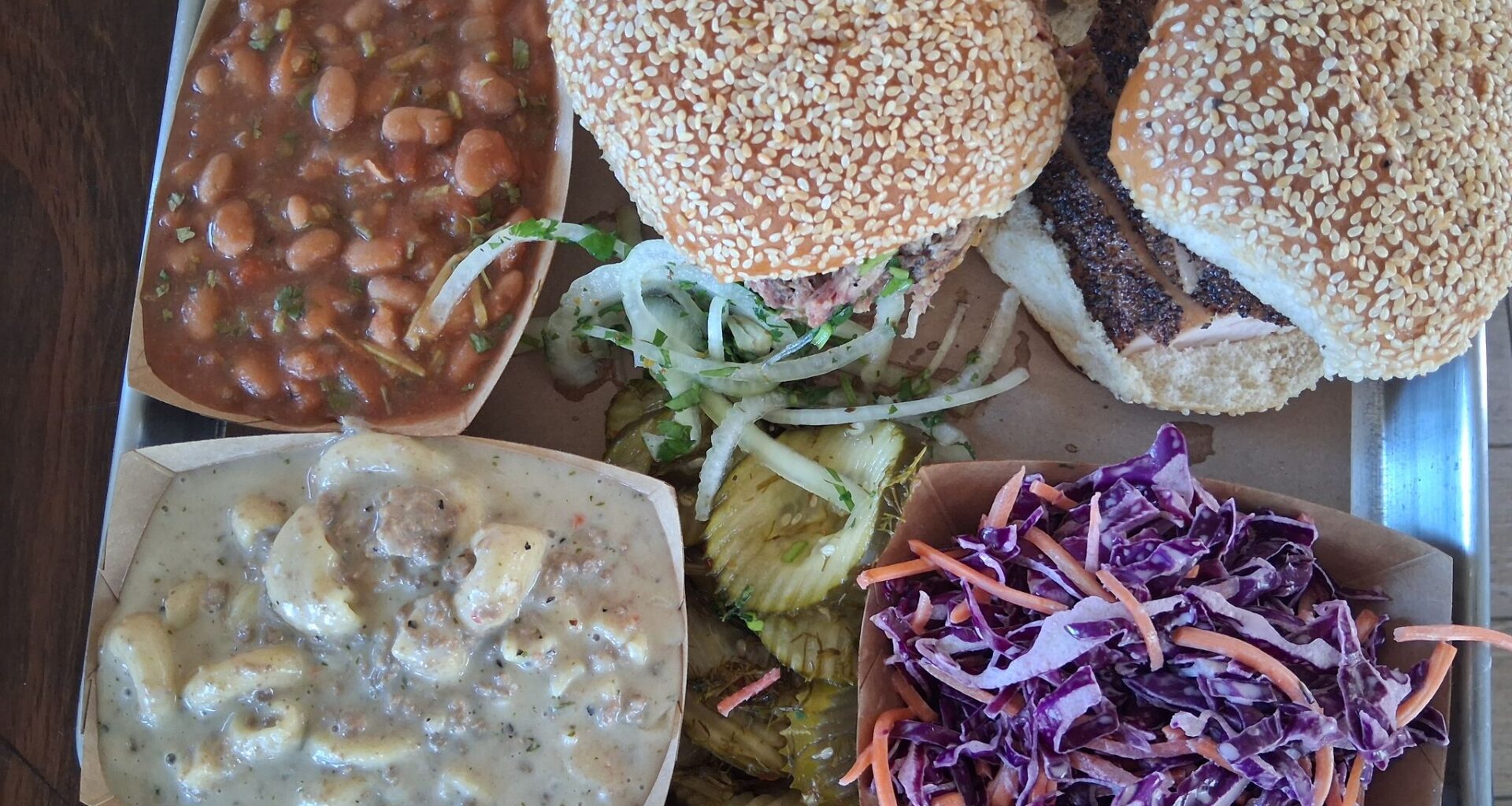 The meal at 2M Smokehouse in San Antonio. It includes a smoked turkey and a pulled pork sandwich, beans, sweet cole slaw, and the star of the tray, picadillo mac and cheese.