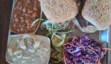 The meal at 2M Smokehouse in San Antonio. It includes a smoked turkey and a pulled pork sandwich, beans, sweet cole slaw, and the star of the tray, picadillo mac and cheese.