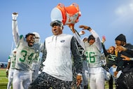 DeSoto head coach Claude Mathis is doused with water after winning a Class 6A Division II...