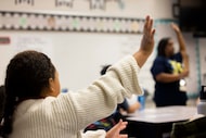 Students raise their hands as third grade teacher Anjelica Turner teaches about character...
