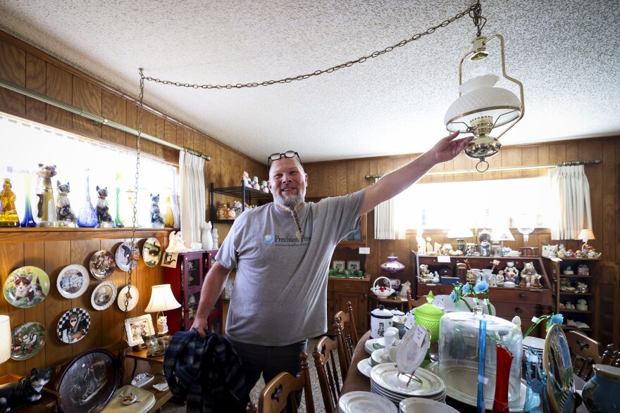 Eric Uzelac with Junk in the Truck DFW turns on a light to show off a cat-themed estate sale dubbed ‘The Crazy Cat Lady Purrrge’ in Arlington. The sale starts at 10 a.m. Friday, Jan. 16, 2026.