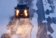 A motorist drives along a snow and ice covered I-35W near Heritage Trace Parkway, Saturday,...