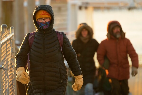 Island commuters are bundled against the cold as they disembark from a ferry on a 1-degree F. morning, Saturday, Jan. 24, 2026, in Portland, Maine. (AP Photo/Robert F. Bukaty)