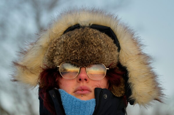 Emma Nadeau, of North Yarmouth, Maine, is bundled against the cold as she watches the sunrise on a 1-degree F. morning, Saturday, Jan. 24, 2026, in Portland, Maine. (AP Photo/Robert F. Bukaty)