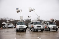 Heavy-duty bucket trucks parked in the parking lot of Hampton Inn & Suites Dallas-Mesquite...