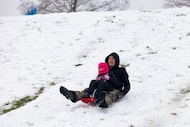 Siblings Johnny and McKinley Fourrier sled together at the Oak Point Park and Nature...