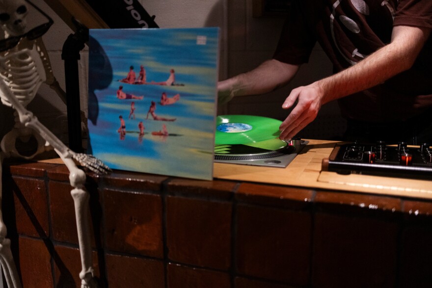 Marshal Spaulding puts a record on a record player at Community Garden.