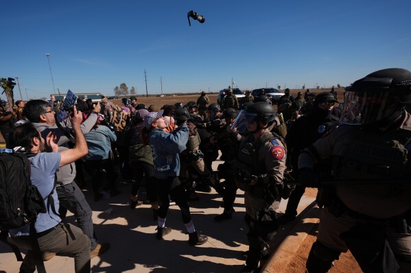 A canister of pepper spray launched by Texas troopers flies towards protesters outside the South Texas Family Residential Center detention facility where Liam Ramos and his father are being detained in Dilley, Texas, Wednesday, Jan. 28, 2026. (AP Photo/Eric Gay)