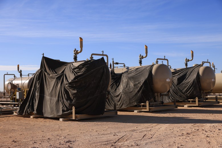 A well owned by Ovintiv produces gas and oil in Midland on Dec. 8, 2021. The black tarps on the tanks are part of Ovintiv's weatherization of their systems.