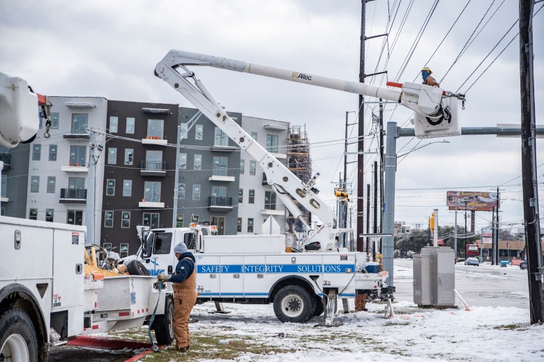 Electrical workers work to repair a power line in Austin on Feb. 18, 2021.