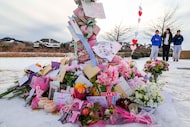 People gather around a makeshift memorial at the site where two girls were involved in...