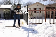 Horacio Tinoco clears his driveway of snow and ice following a winter storm on Wednesday,...