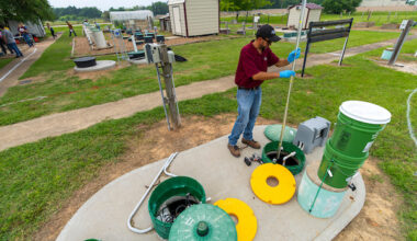 An individual demonstrating how to check a septic system