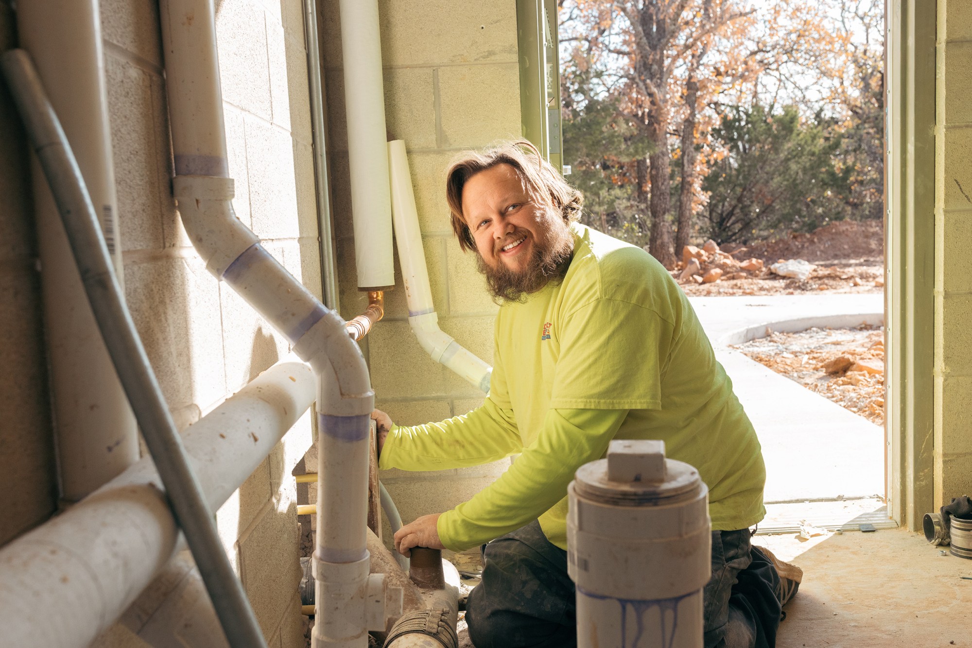 Justin Davis works on the plumbing at a restroom near the campgrounds at Palo Pinto Mountains State Park on Dec. 15, 2025.