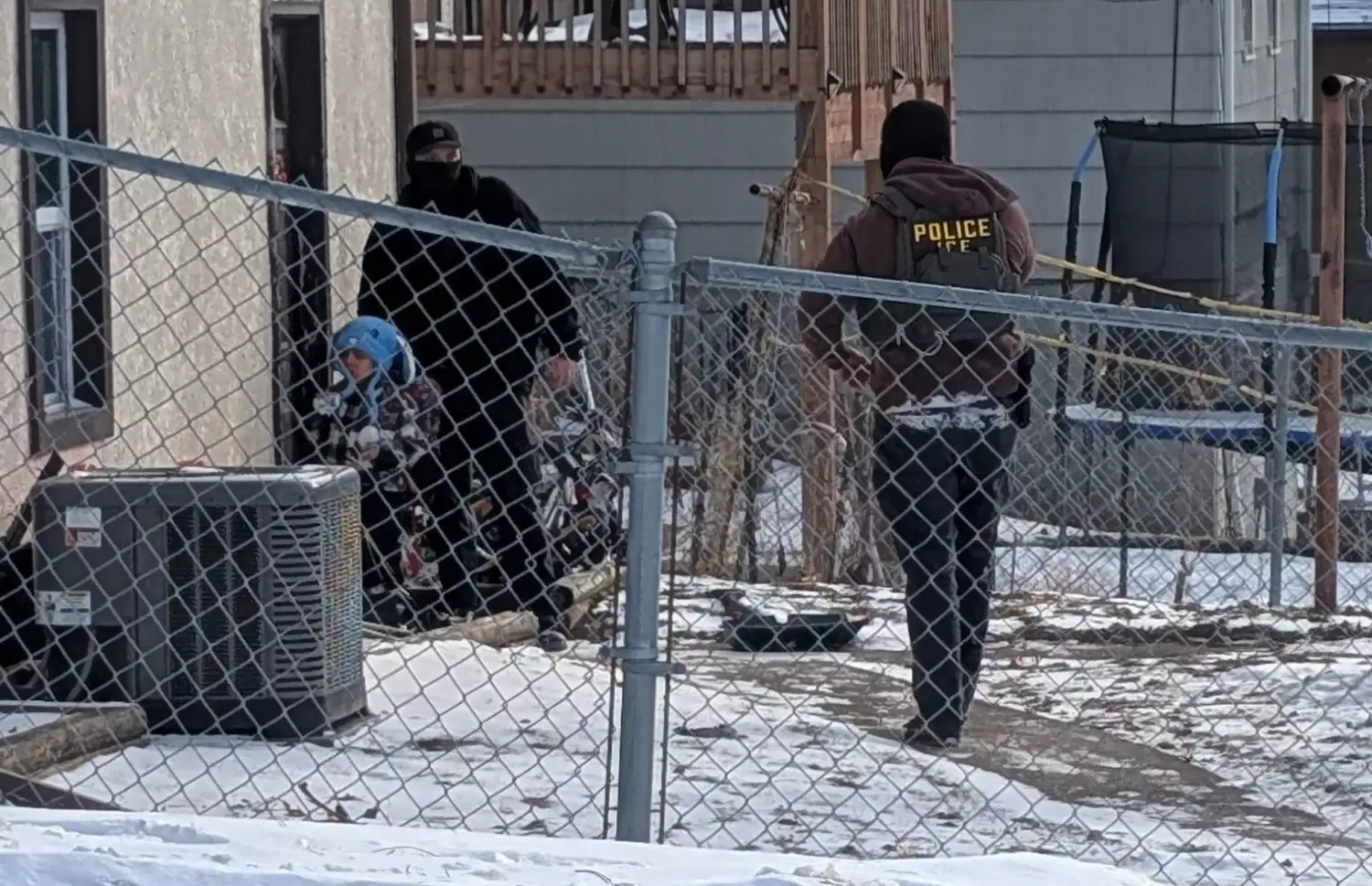 ICE agents stand next to a boy, who a witness identified as Liam Conejo Ramos, a five-year-old that school officials said was detained in Minneapolis, Minnesota, U.S., January 20, 2026. Rachel James/via REUTERS THIS IMAGE HAS BEEN SUPPLIED BY A THIRD PARTY. MANDATORY CREDIT. Reuters verified the location from the road layout, buildings, and fence seen in the video and photographs which matched file and satellite imagery of the area. The date when the visuals were filmed was confirmed by the original file metadata. The school district officials said that a five-year-old was detained on Tuesday (January 20).
