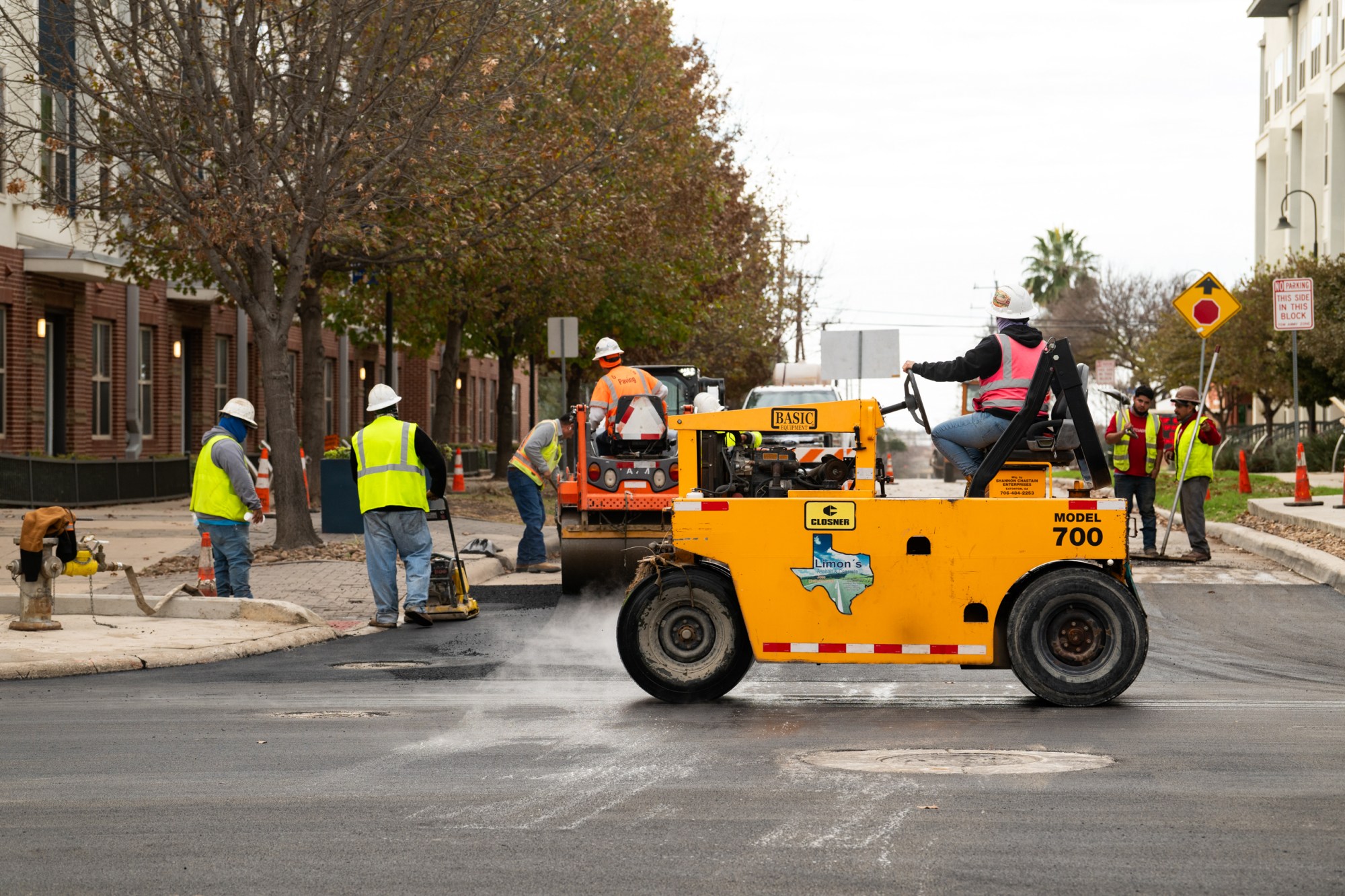 City workers pave over the rainbow crosswalk at the intersection of North Main Avenue and Evergreen Street on Jan. 13, 2026 in San Antonio.